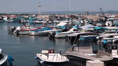 Nesebar, Bulgaristan - 25 Ağustos 2025: Bir sürü küçük teknesi olan deniz iskelesi. Sakin sulara demirlemiş tekneleri olan bir liman. Karadeniz kıyısında sudaki sürat tekneleri. Deniz kenarı manzarası