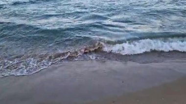 Denizde fırtınalı bir hava, yakından gelen dalgalar. Bulgaristan ve Pomorie kenti yakınlarındaki Karadeniz. Akşamları kıyıya yakın denizde dalgalar. Deniz akşam manzarası. Tatil köyünde tatil kavramı