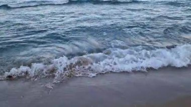 Denizde fırtınalı bir hava, yakından gelen dalgalar. Bulgaristan ve Pomorie kenti yakınlarındaki Karadeniz. Akşamları kıyıya yakın denizde dalgalar. Deniz akşam manzarası. Tatil köyünde tatil kavramı