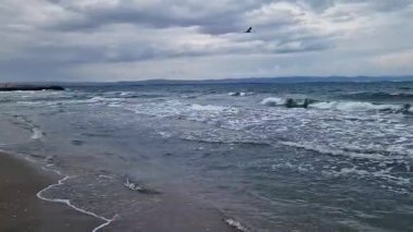 Denizde fırtınalı bir hava, yakından gelen dalgalar. Bulgaristan ve Pomorie kenti yakınlarındaki Karadeniz. Akşamları kıyıya yakın denizde dalgalar. Deniz akşam manzarası. Tatil köyünde tatil kavramı