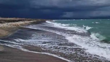 Denizde fırtınalı bir hava, yakından gelen dalgalar. Bulgaristan ve Pomorie kenti yakınlarındaki Karadeniz. Akşamları kıyıya yakın denizde dalgalar. Deniz akşam manzarası. Tatil köyünde tatil kavramı