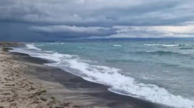 Denizde fırtınalı bir hava, yakından gelen dalgalar. Bulgaristan ve Pomorie kenti yakınlarındaki Karadeniz. Akşamları kıyıya yakın denizde dalgalar. Deniz akşam manzarası. Tatil köyünde tatil kavramı