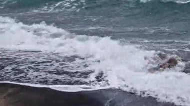 Denizde fırtınalı bir hava, yakından gelen dalgalar. Bulgaristan ve Pomorie kenti yakınlarındaki Karadeniz. Akşamları kıyıya yakın denizde dalgalar. Deniz akşam manzarası. Tatil köyünde tatil kavramı