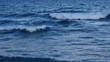 Kıyıya yakın denizde dalgalar. Deniz akşam manzarası. Bulgaristan ve Pomorie kenti yakınlarındaki Karadeniz. Kıyıya yakın bir yerde köpüklü dalgalar salla. Tatil köyünde tatil kavramı. Plaj tatili