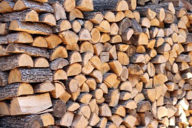 Duvar boyunca yığılmış odun yığını. Ahşap kütükler kes. Sokağın avlusundaki duvarda depolanmış yakacak odunlar. Kışın soba için yakıt. Odun, kurutmak için istiflenir.