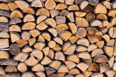 Duvar boyunca yığılmış odun yığını. Ahşap kütükler kes. Sokağın avlusundaki duvarda depolanmış yakacak odunlar. Kışın soba için yakıt. Odun, kurutmak için istiflenir.