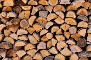 Duvar boyunca yığılmış odun yığını. Ahşap kütükler kes. Sokağın avlusundaki duvarda depolanmış yakacak odunlar. Kışın soba için yakıt. Odun, kurutmak için istiflenir.