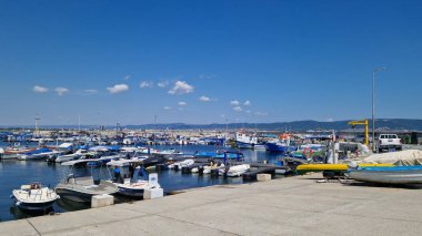 Nessebar, Bulgaristan - 25 Ağustos 2025: Bir sürü küçük teknesi olan deniz iskelesi. Sakin sulara demirlemiş tekneleri olan bir liman. Karadeniz kıyısında sudaki sürat tekneleri. Deniz kenarı manzarası