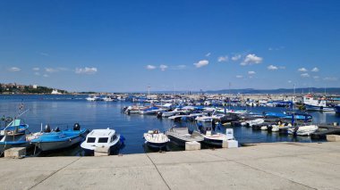 Nessebar, Bulgaristan - 25 Ağustos 2025: Bir sürü küçük teknesi olan deniz iskelesi. Sakin sulara demirlemiş tekneleri olan bir liman. Karadeniz kıyısında sudaki sürat tekneleri. Deniz kenarı manzarası