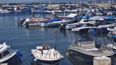 Nessebar, Bulgaristan - 25 Ağustos 2025: Bir sürü küçük teknesi olan deniz iskelesi. Sakin sulara demirlemiş tekneleri olan bir liman. Karadeniz kıyısında sudaki sürat tekneleri. Deniz kenarı manzarası