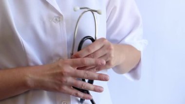 Stetoskop tutan bir doktorun yakın çekimi. Bir hemşirenin ellerine steteskopla yakın çekim, beyaz önlüklü bir doktor veya terapist. Sağlık ve tıp konsepti. Tıbbi aletli bir terapist.