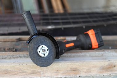 Akülü bileme makinesi. Elektrikli alet, yakın plan. Açı öğütücü verandada. Tamir ve inşaat aletleri. Saplı açı öğütücü