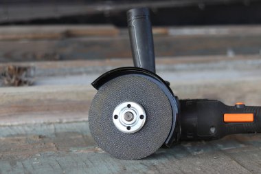 Akülü bileme makinesi. Elektrikli alet, yakın plan. Açı öğütücü verandada. Tamir ve inşaat aletleri. Saplı açı öğütücü