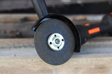 Akülü bileme makinesi. Elektrikli alet, yakın plan. Açı öğütücü verandada. Tamir ve inşaat aletleri. Saplı açı öğütücü