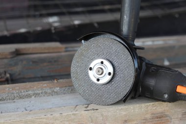 Akülü bileme makinesi. Elektrikli alet, yakın plan. Açı öğütücü verandada. Tamir ve inşaat aletleri. Saplı açı öğütücü