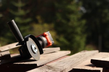 Akülü bileme makinesi. Elektrikli alet, yakın plan. Açı öğütücü verandada. Tamir ve inşaat aletleri. Saplı açı öğütücü