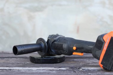 Akülü bileme makinesi. Elektrikli alet, yakın plan. Açı öğütücü verandada. Tamir ve inşaat aletleri. Saplı açı öğütücü