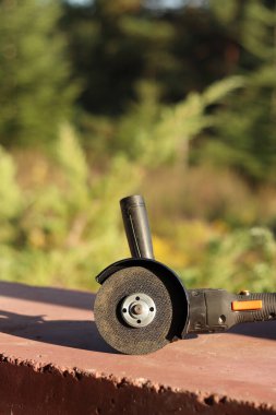 Akülü bileme makinesi. Elektrikli alet, yakın plan. Açı öğütücü verandada. Tamir ve inşaat aletleri. Saplı açı öğütücü