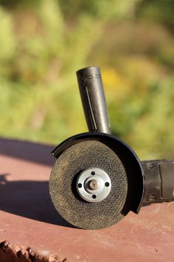 Akülü bileme makinesi. Elektrikli alet, yakın plan. Açı öğütücü verandada. Tamir ve inşaat aletleri. Saplı açı öğütücü