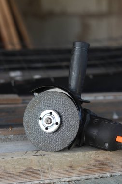 Akülü bileme makinesi. Elektrikli alet, yakın plan. Açı öğütücü verandada. Tamir ve inşaat aletleri. Saplı açı öğütücü