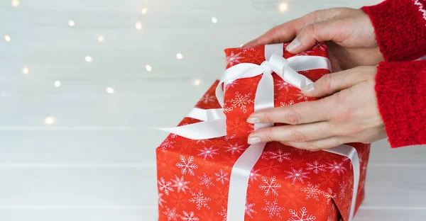 女性の手はクリスマスや新年のための赤いギフトボックスを保持しています 新年とクリスマスの休日のための贈り物を購入する 何かあったの スペースのコピー — ストック写真