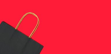 Kırmızı arka planda kağıt siyah alışveriş torbası. Kara Cuma. Model yap. Pankart. Üst Manzara. Mesaj için yer. Düz Yatay.