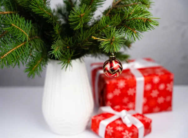 花瓶やギフトボックスにクリスマスツリーの枝とお祭りの組成 新年とクリスマスへの贈り物 クリスマスツリーの装飾 選択的焦点 — ストック写真