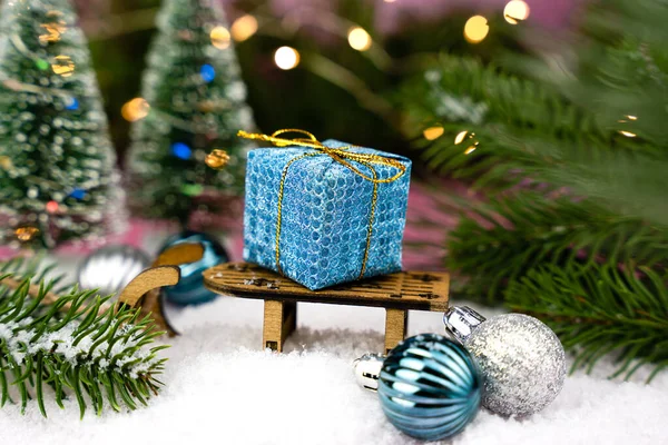 雪の背景にギフトボックスや装飾的な小さなそりとお祭りの新年やクリスマスの組成物 新年の挨拶カード 接近中だ 選択的焦点 — ストック写真