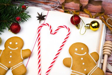 Yemek tarifi kitabı, zencefilli çörek adamlar, lolipopların kalbi ve Noel süsü. Pişirme konsepti. Noel, yeni yıl ve sevgililer günü hediyeleri. Yakın plan. Üst görünüm.