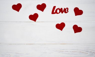 Sevgililer Günü tatili konsepti. Kırmızı kalpler ve beyaz ahşap arka planda aşk kelimesi. Pankart. Üst Manzara. Flatlay. Boşluğu kopyala.