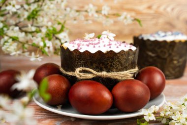 Spring Easter composition with Easter cake and colored eggs on the table. Festive Easter card. Close-up. Selective focus.