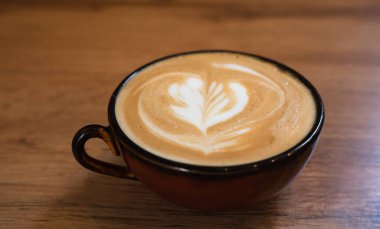 A cup of fresh fragrant cappuccino on a table at the cafe. Close-up. Selective focus.