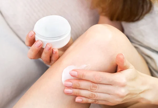 stock image Body care at home. Young girl applying cream after depilation. Close-up. Selective focus.