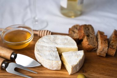 Krem peynirli Camembert, tatlım ve ahşap bir arka planda taze çıtır ekmek. Yakın plan. Seçici odak.