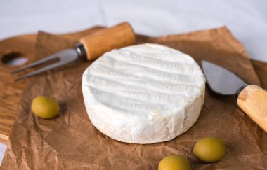 Beyaz küflü peynirli, zeytinli, çatallı ve bıçaklı. Yakın plan. Seçici odak.