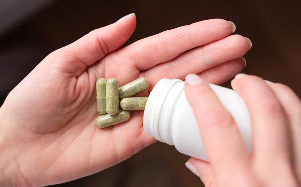 Női Kéz Gyógynövényeket Öntött Egy Üvegből Kezében Vitaminok Étrend Kiegészítő — Stock Fotó