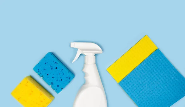 Cleaning products on a blue background. Top view. Copy space.