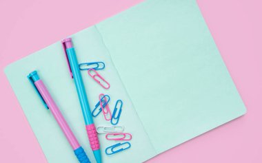 Pembe arka planda renkli kırtasiye malzemesi ve metin için yer var. Flatlay. Okula dönelim. Üst görünüm.