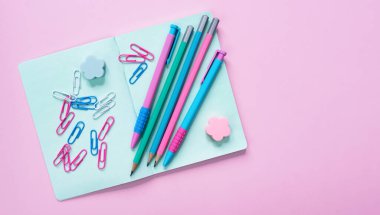 Pembe arka planda renkli kırtasiye malzemesi. Okula dönelim. Flatlay. Üst Manzara. Boşluğu kopyala.