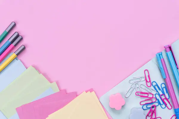 School stationery lie in the shape of a frame on pink background. Back to school. Flatlay. Top view. Copy space.