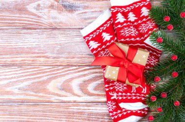 Noel dekoru, hediye kutusu ve beyaz ahşap arka planda örülmüş çoraplı şenlikli düz yatak kompozisyonu. Üst Manzara. Uzayı kopyala Seçici odak.