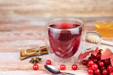Tahta bir masada tarçınlı ve ballı sağlıklı viburnum çayı. Yakın plan. Uzayı kopyala Seçici odak.