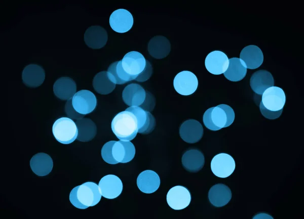 Siyah arka planda bulanık mavi bokeh ışıkları. Seçici odak.