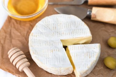 Peynirli Camembert peyniri, zeytin ve bal masada. Fransız kahvaltısı. Yakın plan. Seçici odak.