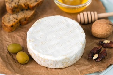 Peynirli Camembert peyniri, zeytin, bal, fındık ve masada taze ekmek. Fransız kahvaltısı. Yakın plan. Seçici odak.