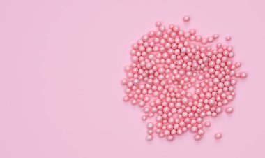 Tatil konsepti. Pembe arka planda dekoratif küçük pembe toplar. Üst Manzara. Boşluğu kopyala.
