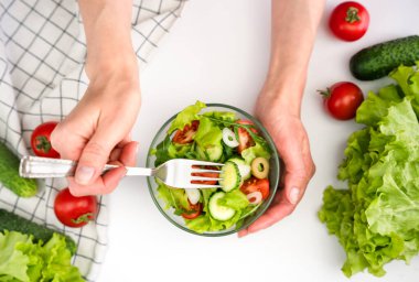 Kadın sağlıklı bir diyet salatası yiyor. Üst Manzara. Sağlıklı gıda konsepti. Seçici odak.