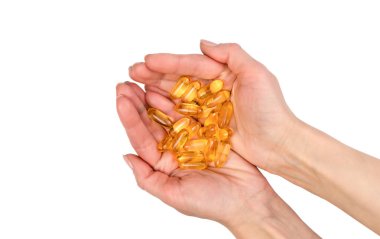 Genç bir kadının elleri beyaz arka planda izole edilmiş bir avuç dolusu Omega-3 yağ asidi tutuyor. Vitamin ve takviye alıyor. Sağlıklı bir yaşam tarzı. Üst Manzara. Yakın plan..