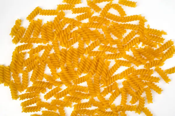 Beyaz zemin üzerinde Fusilli macunu sarmal şekli. Makarna arkaplanı. Üst Manzara. Seçici odak.