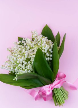 Pembe arka planda vadideki zambaklar. Anneler Günü, 8 Mart, Sevgililer Günü konsepti. Flatlay. Üst Manzara. Uzayı kopyala Seçici odak.